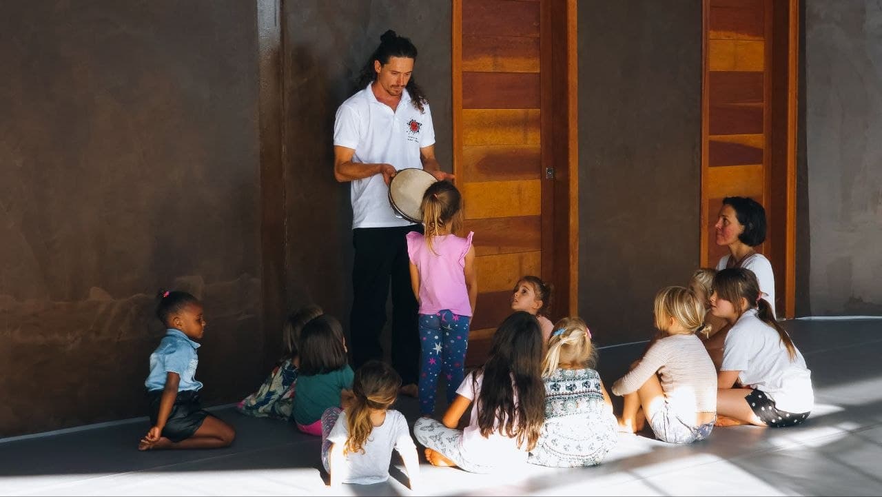Aula de música e movimento no ZUZ — mestre com pandeiro e crianças em roda